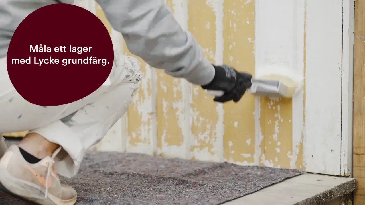 En person m&aring;lar en gulnad tr&auml;fasad med vit grundf&auml;rg. Det &auml;r viktigt att man grundm&aring;lar utomhus f&ouml;r ett h&aring;llbart resultat.