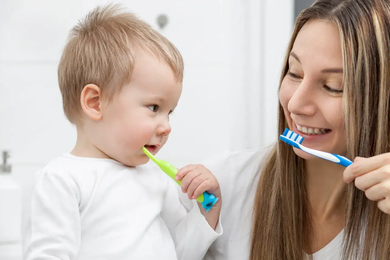 Mama uczy malucha myć zęby. Dzieci które nie myją zębów szybko się psują, dlatego warto dbać o higienę od najmłodszych lat.