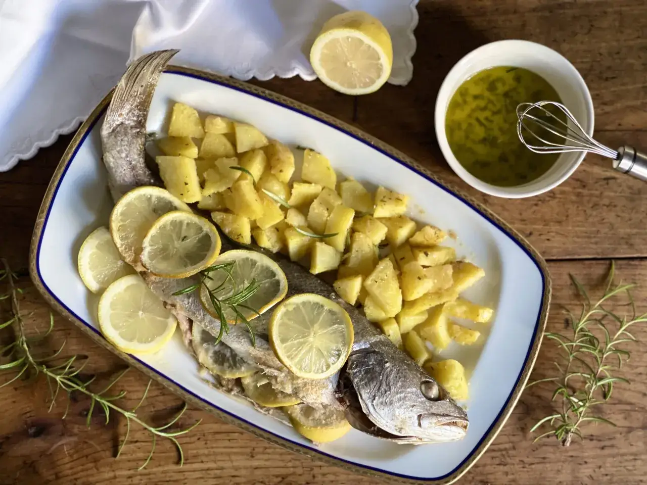 Ombrina al forno con patate, limone e rosmarino, un piatto semplice e gustoso.