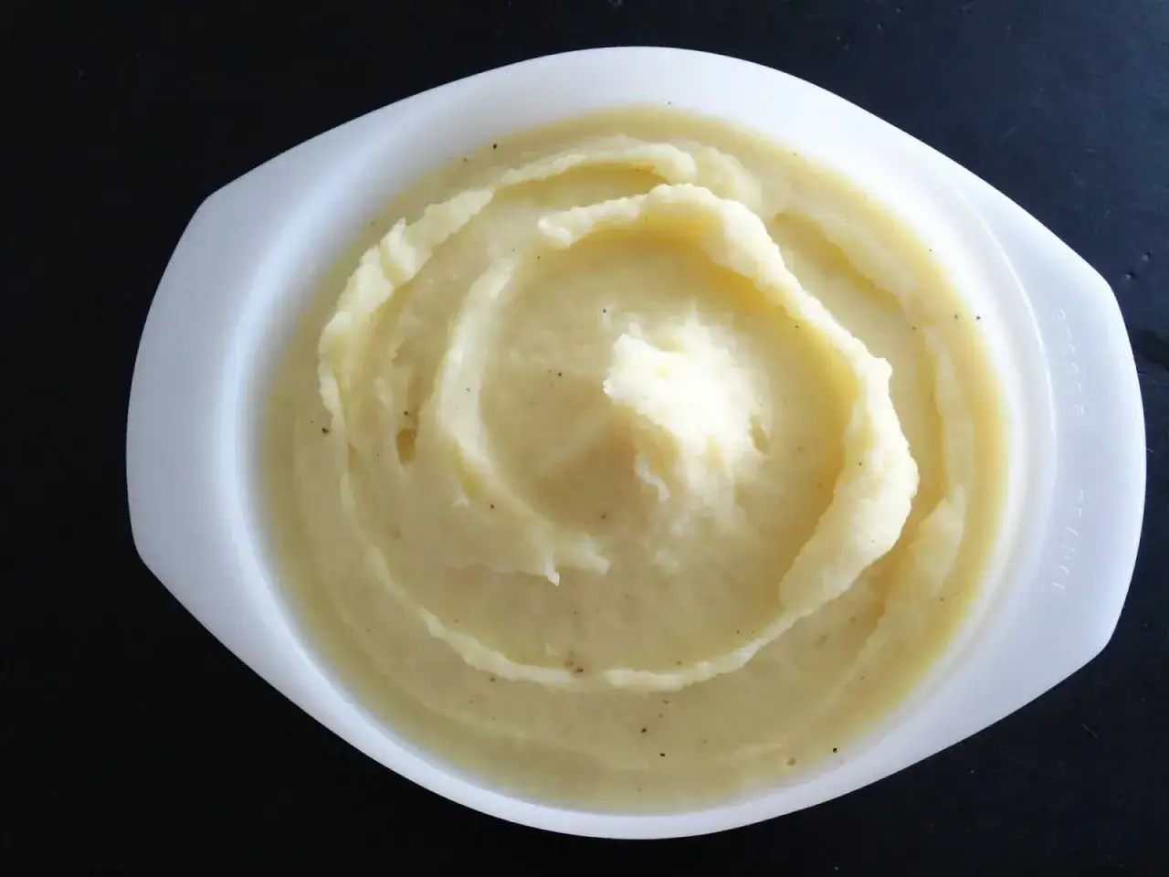 Puré de patatas cremoso y suave, hecho con Thermomix, servido en un cuenco blanco.