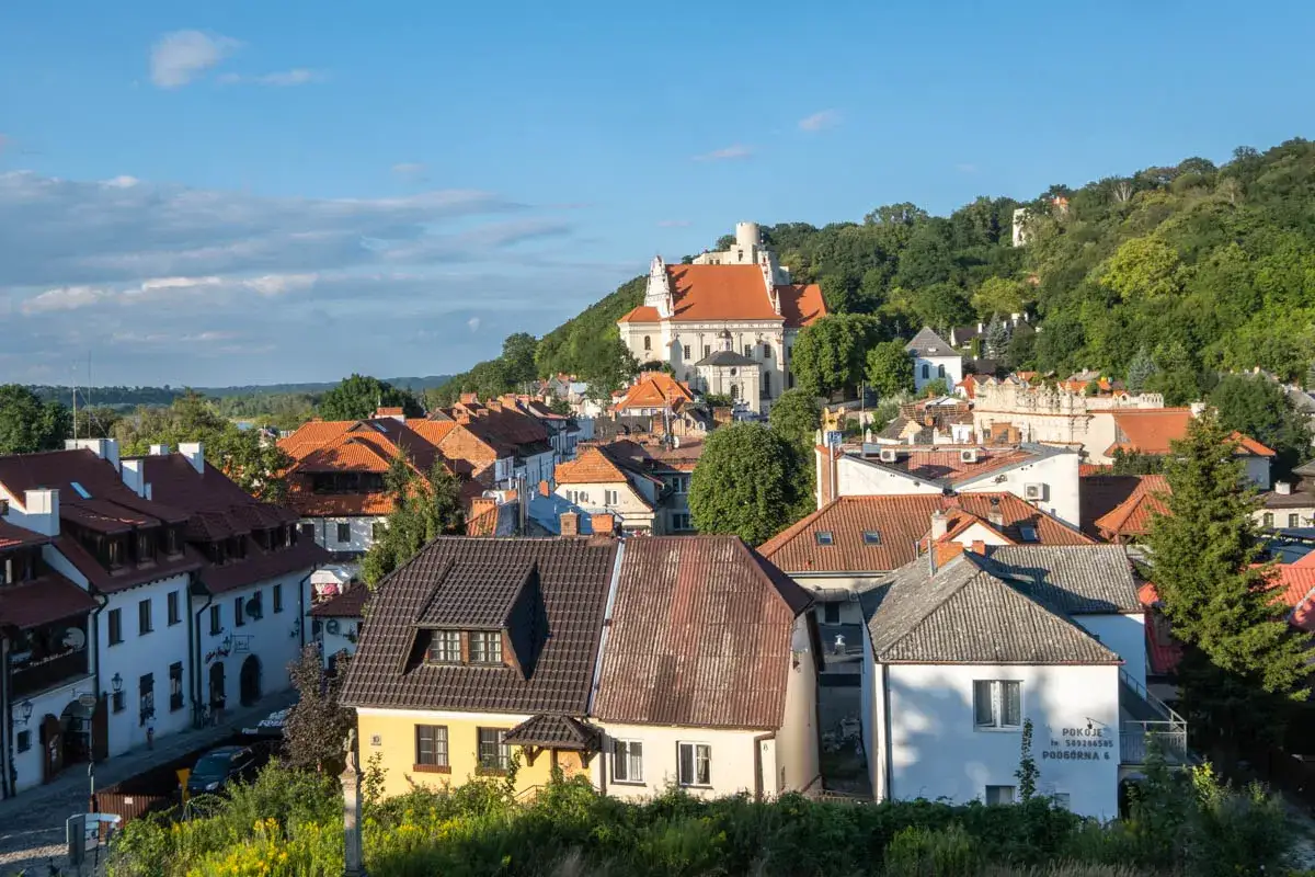 Urokliwa miejscowość Kazimierz Górny z charakterystyczną architekturą i kościołem na wzgórzu.