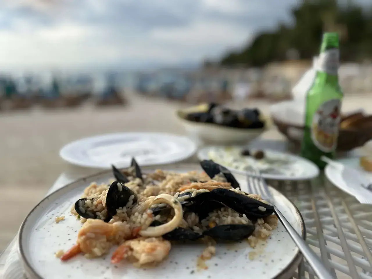 Pyszne risotto z owocami morza na talerzu, w jednej z saranda restauracji, z widokiem na plażę i morze.