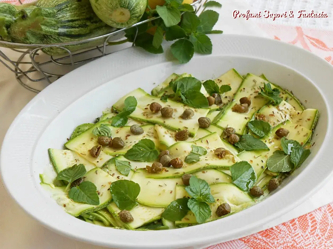 Delicato carpaccio di zucchine con capperi e menta fresca, un piatto estivo leggero e saporito.