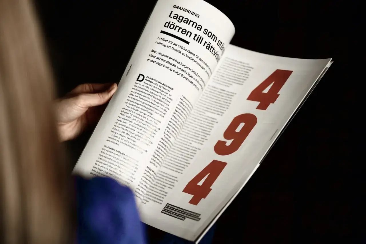 En hand h&aring;ller i en tidning med rubriken 