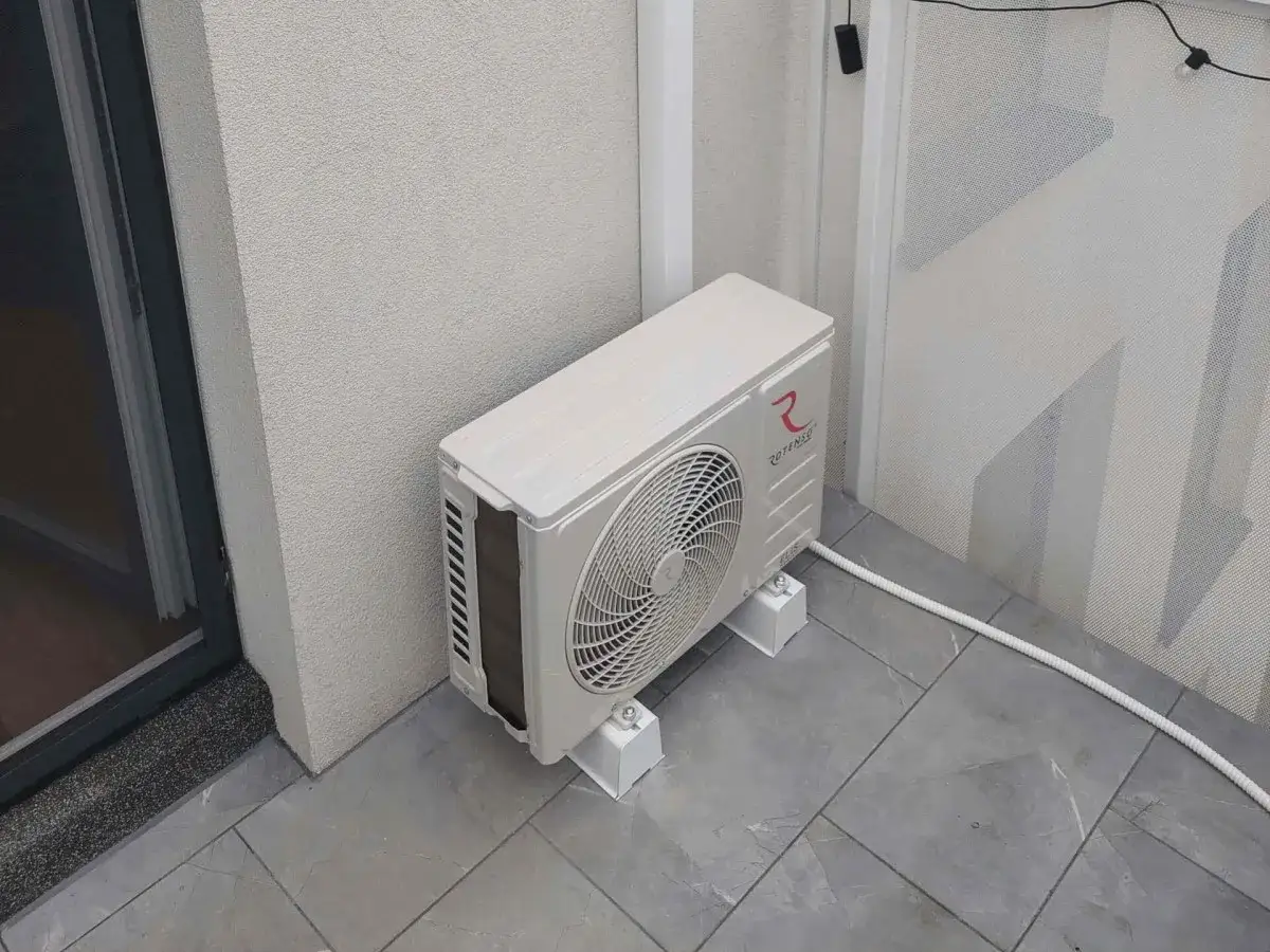 Jednostka zewnętrzna klimatyzatora na balkonie.