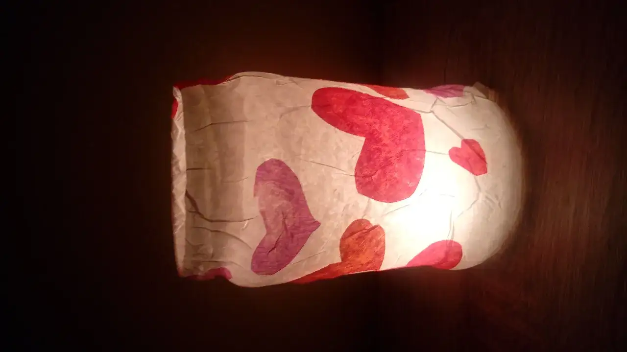 Lampion z papieru z serduszkami, idealny jako ozdoby walentynkowe diy. Ciepłe światło przebija przez kolorowe serca.