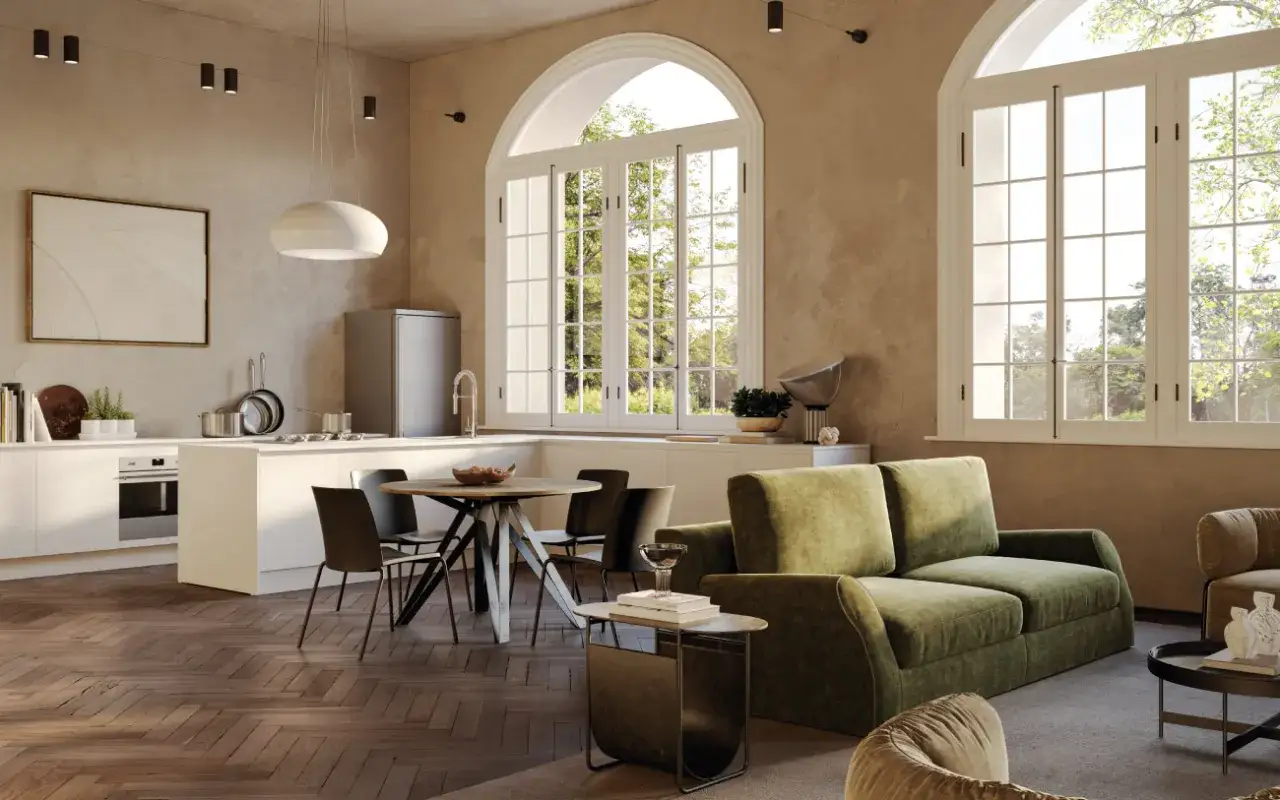 Interni open space di case moderne: cucina bianca, tavolo rotondo, divano verde e grandi finestre con vista sul giardino.