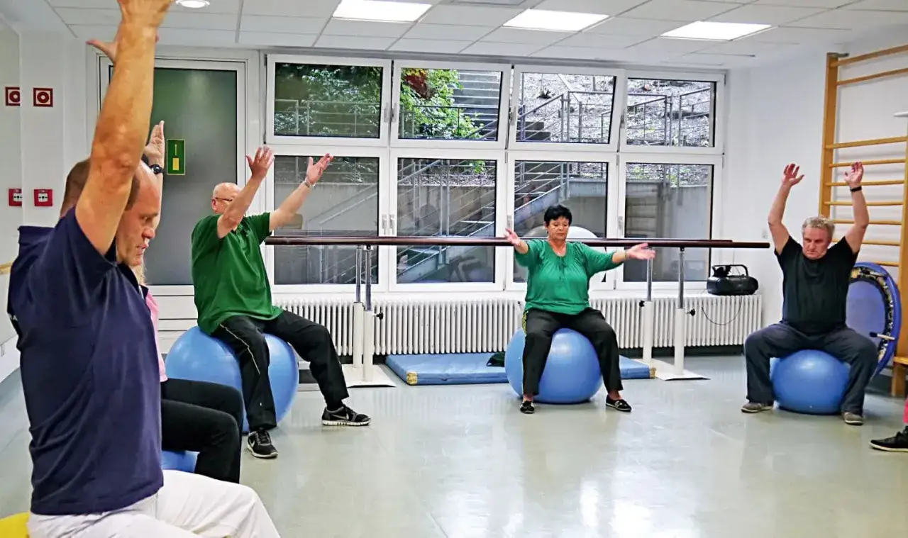 Senioren mit COPD trainieren im Sitzen auf Gymnastikb&auml;llen. Dieser Sport hilft ihnen, ihre Lungenfunktion zu verbessern und fitter zu werden.