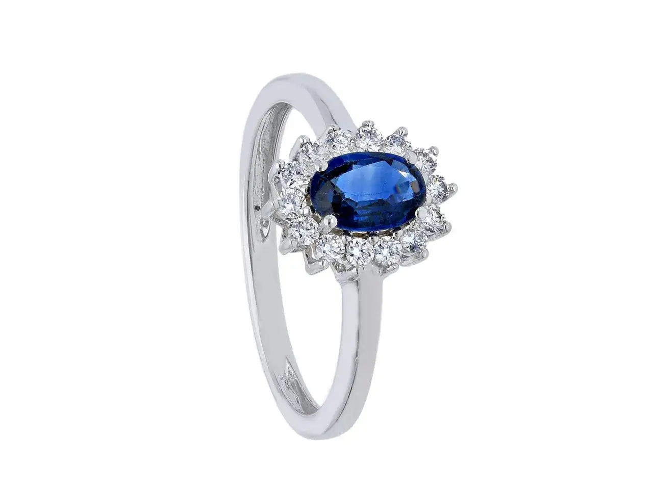 Anello in oro bianco con zaffiro blu centrale, circondato da diamanti. Il **zaffiro blu significato** &egrave; saggezza e nobilt&agrave;.