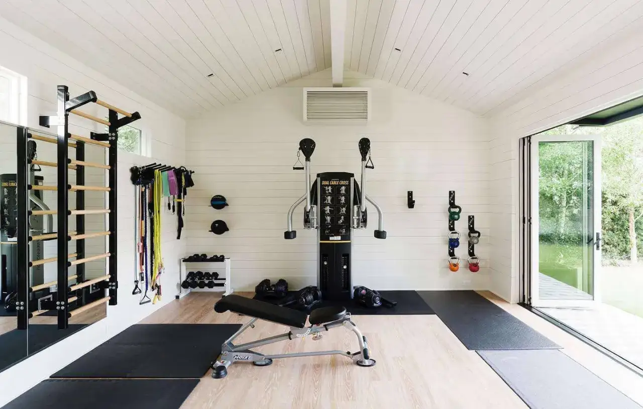 V&auml;lutrustat gym i garaget med kl&auml;tterst&auml;llning, kabelmaskin, b&auml;nk, vikter och tr&auml;ningsband.
