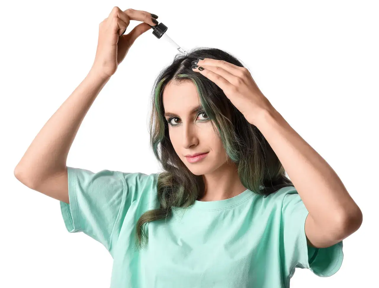 Mujer aplicando minoxidil en el cuero cabelludo para estimular el crecimiento del pelo.