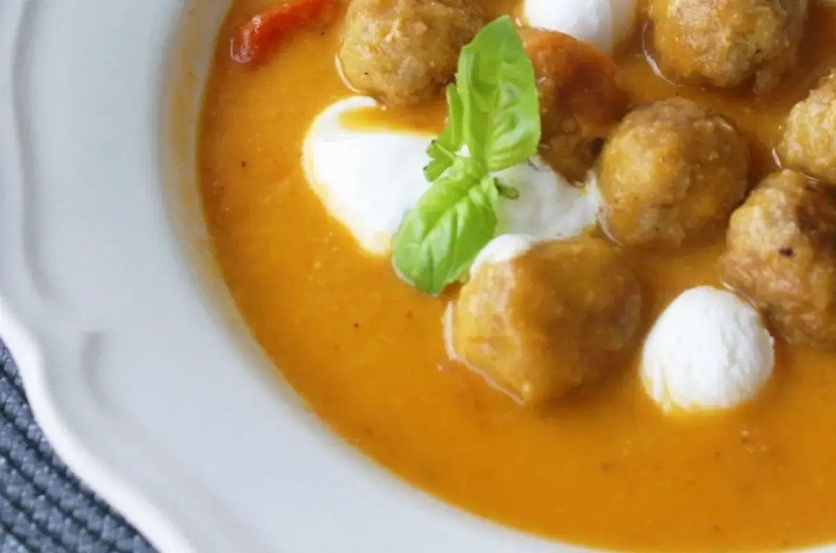 Aksamitna zupa królewska z pulpecikami, kulkami mozzarelli i listkiem bazylii.