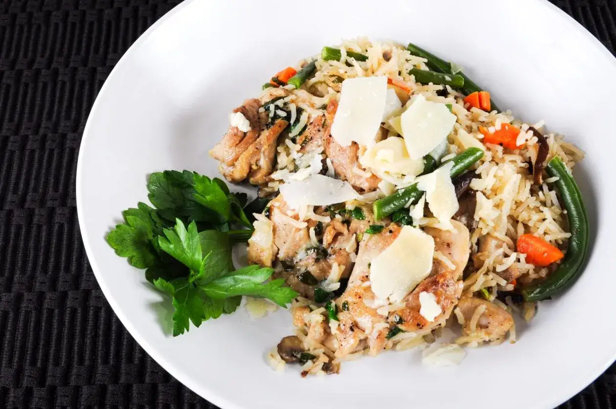 H&auml;hnchen mit Reis, gr&uuml;nen Bohnen und Karotten, garniert mit Parmesan. Ein leichtes Gericht, das sich gut f&uuml;r schonkost rezepte eignet.