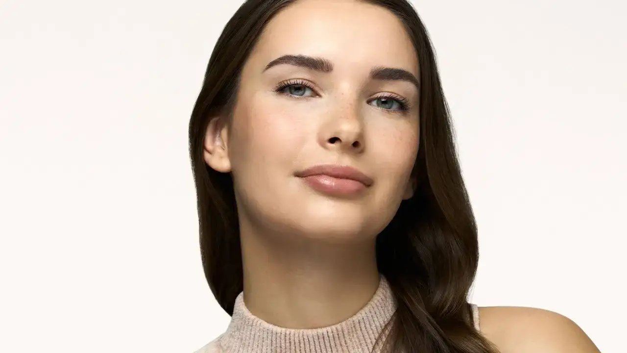 Ragazza con trucco naturale, labbra luminose e sopracciglia definite. Un esempio di come fare un make up perfetto per esaltare la bellezza.