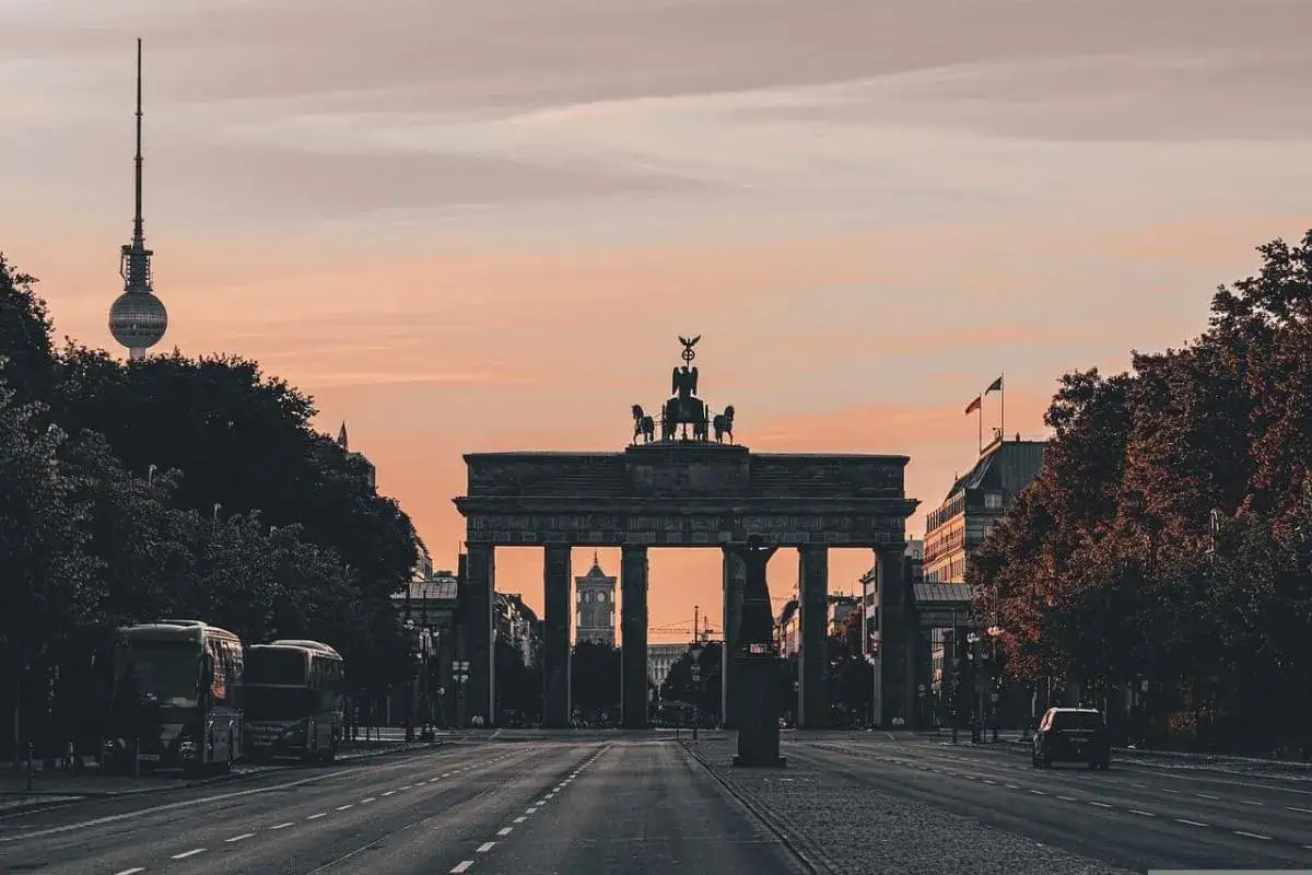 Porta di Brandeburgo al tramonto, con la Torre della Televisione sullo sfondo. Un'atmosfera tranquilla, lontana dal caos di un tipico berlin club.