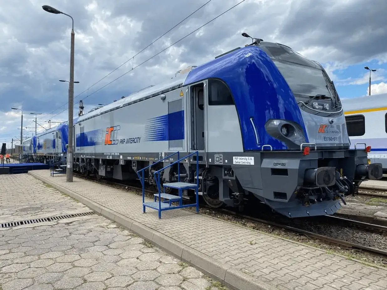 Lokomotywa EU160-018 PKP Intercity gotowa do podróży. Nowoczesny, szaro-niebieski pojazd stoi na torach.