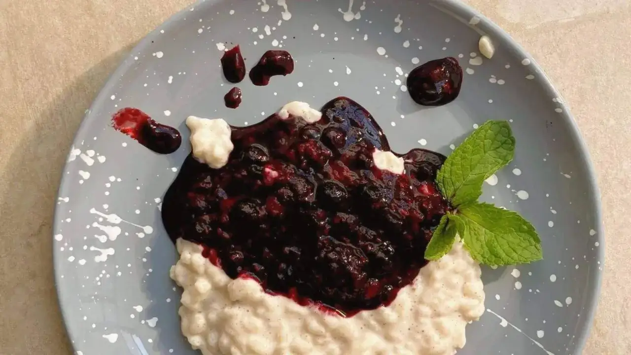 Cremiger Milchreis mit dunkler Beerenso&szlig;e und Minze. Ein einfaches Milchreis Rezept, das immer gelingt.
