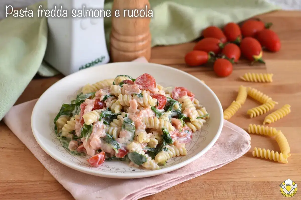 Piatto di pasta fredda con salmone, pomodorini e rucola, condita con una cremosa salsa. Un'esplosione di freschezza e sapore.
