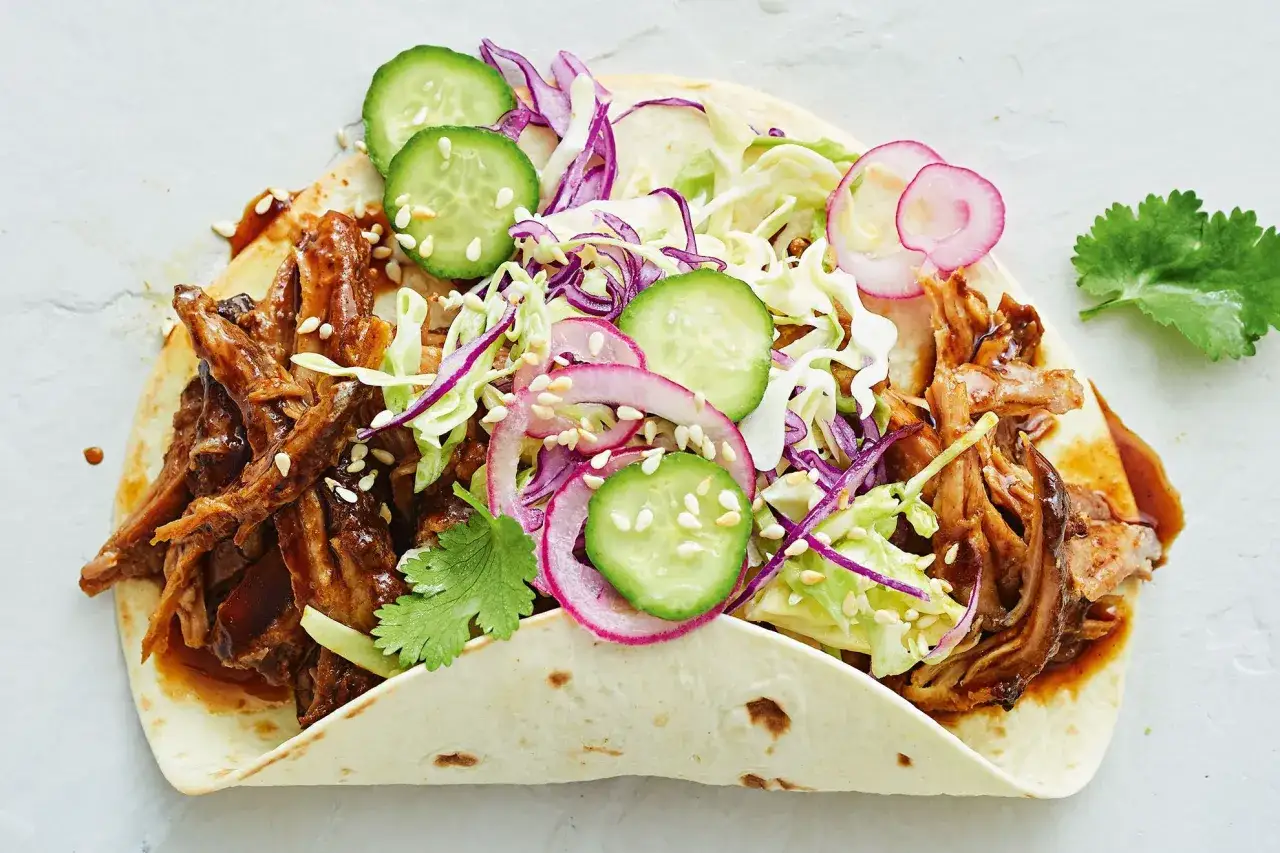 En taco fylld med saftig koreansk pulled pork, krispig k&aring;lsallad, gurka och r&auml;disor.