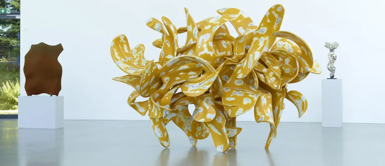 Tony Cragg Skulpturen in Wuppertal: eine gelbe, wirbelnde Form neben einer braunen und einer silbernen.