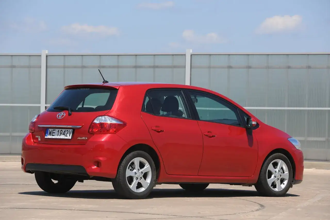 Czerwony Toyota Auris, widok z tyłu. Czas na wymianę żarówki tablicy rejestracyjnej.