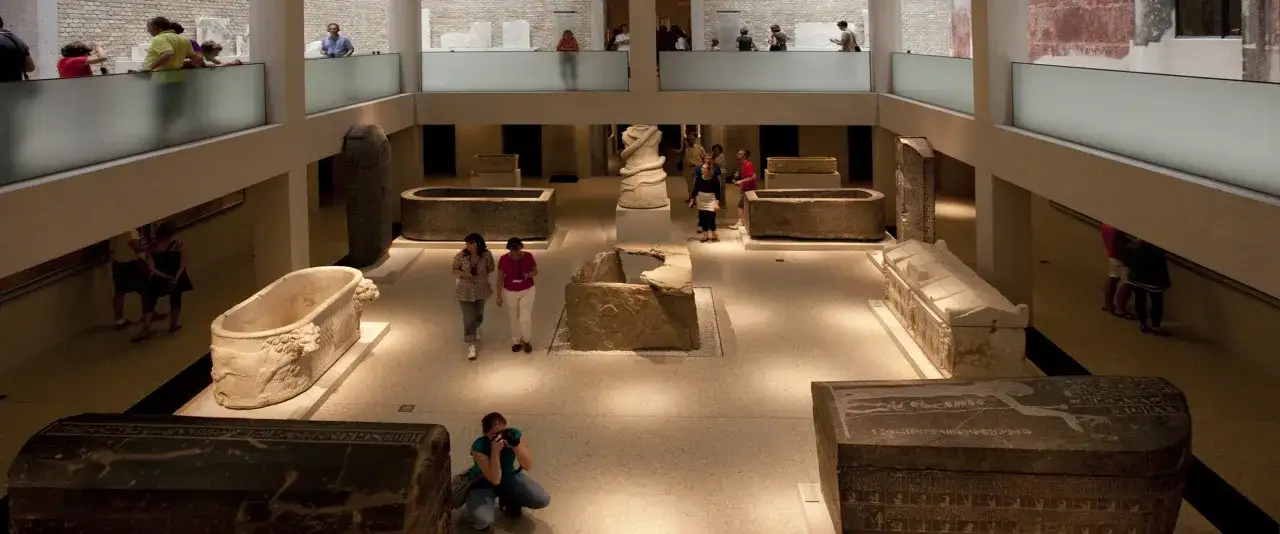 Zwiedzający podziwiają starożytne sarkofagi i rzeźby w nowym muzeum w Berlinie.