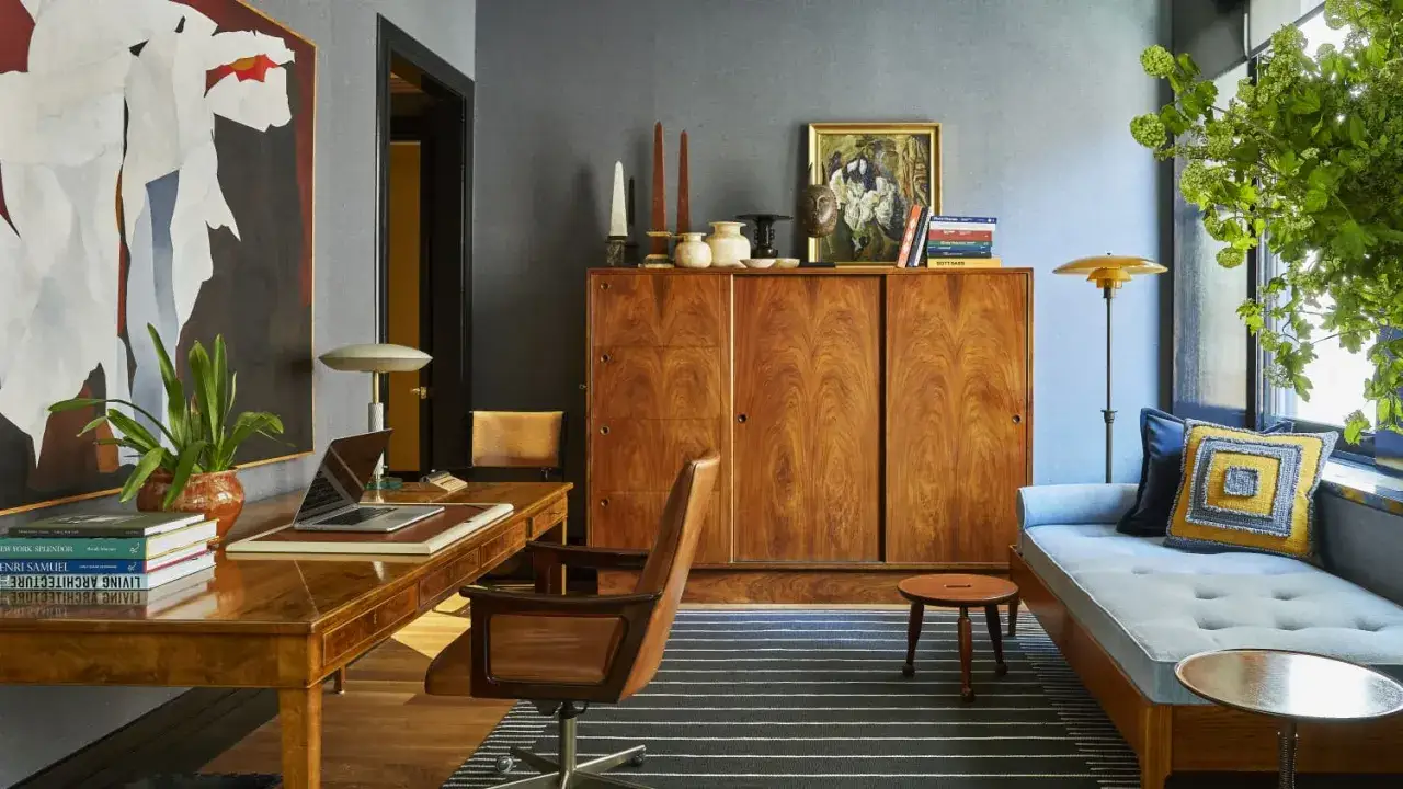 A home office showcasing mid-century modern wood furniture styles, featuring a rich walnut desk, a large cabinet, and a daybed.
