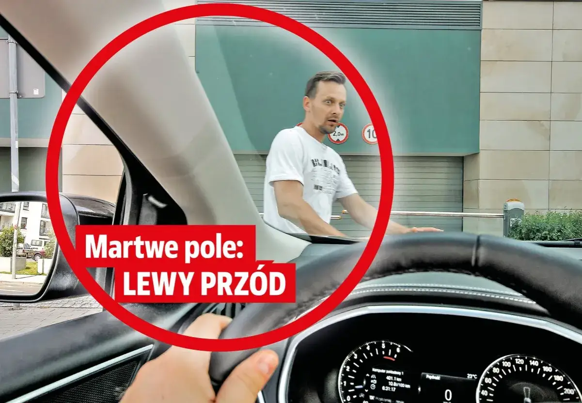 Mężczyzna w białej koszulce zszokowany, bo nie widzi w martwym polu lewy prz&oacute;d samochodu.