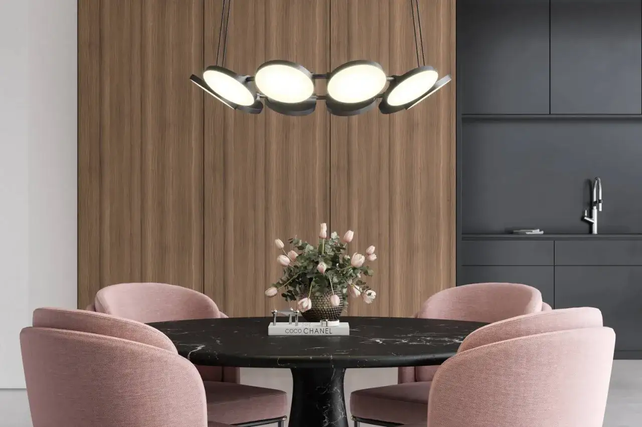 Modern lampa till runt matbord med rosa stolar och blommor. En elegant belysning som skapar stämning.