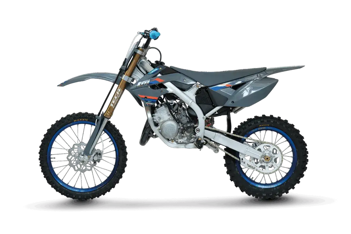 Szary motocykl crossowy z niebieskimi felgami, idealny jako pierwszy cross dla 14 latka.