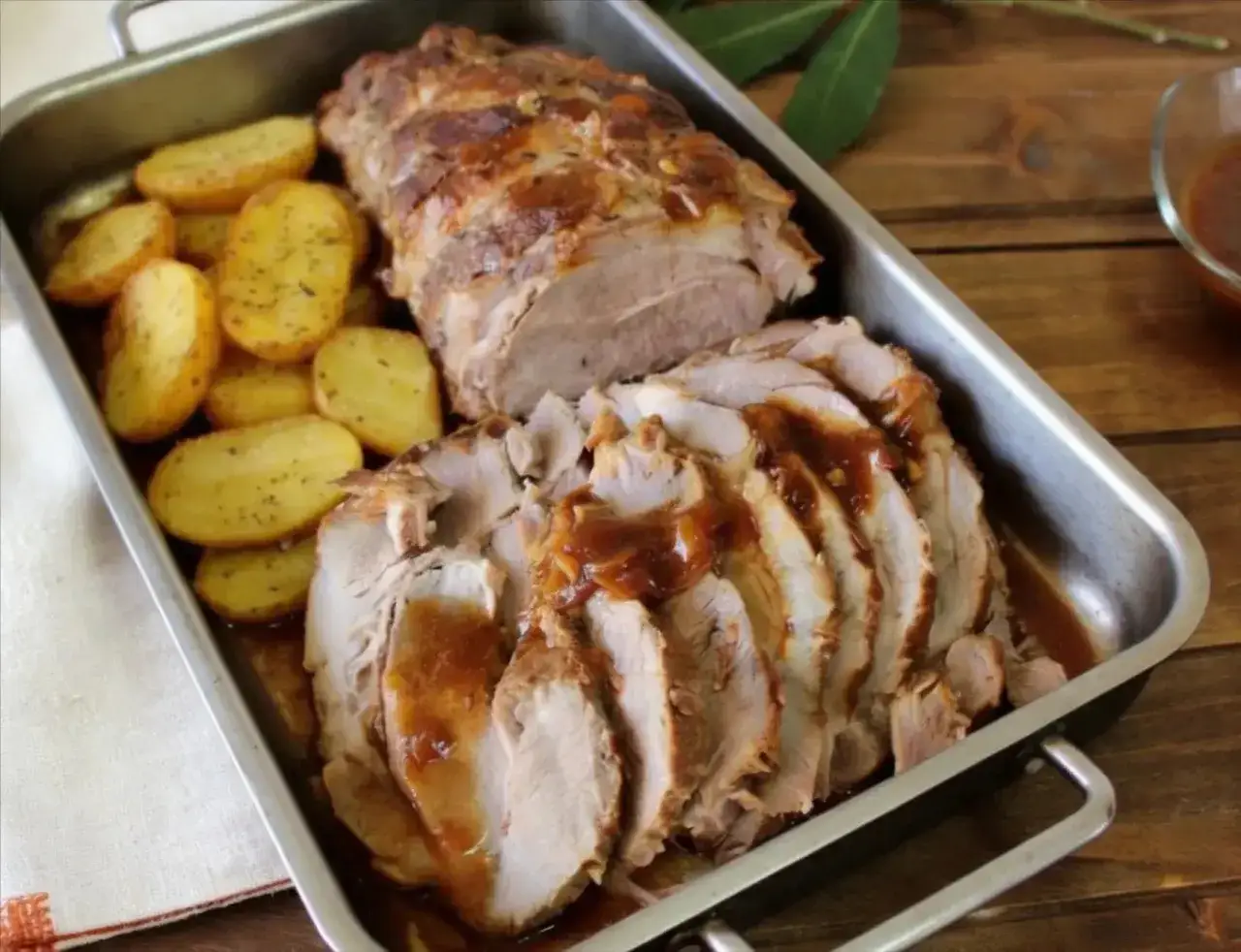 Jugosa cabezada de cerdo asada, cortada en lonchas y ba&ntilde;ada en su jugo, acompa&ntilde;ada de patatas doradas.
