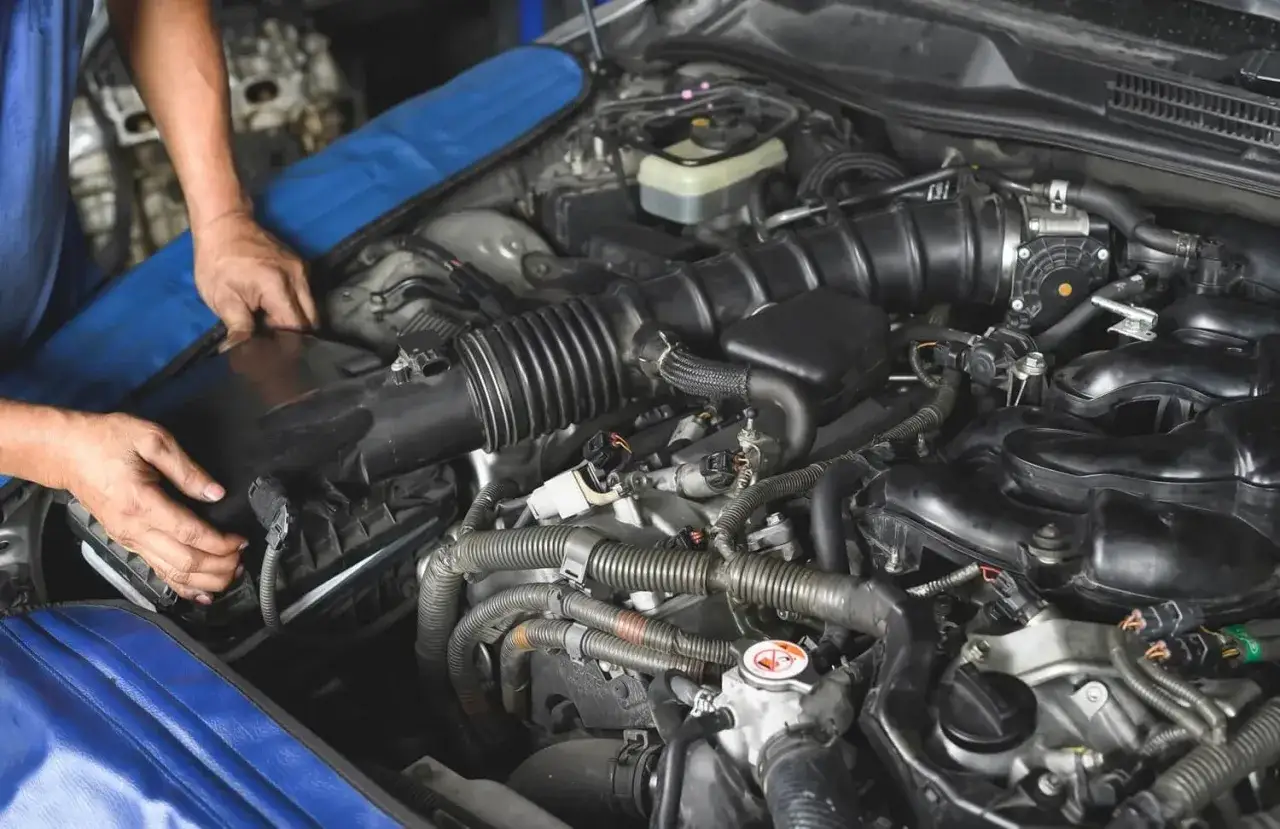Mechanik sprawdza nieszczelny dolot, który może powodować problemy z pracą silnika benzynowego.