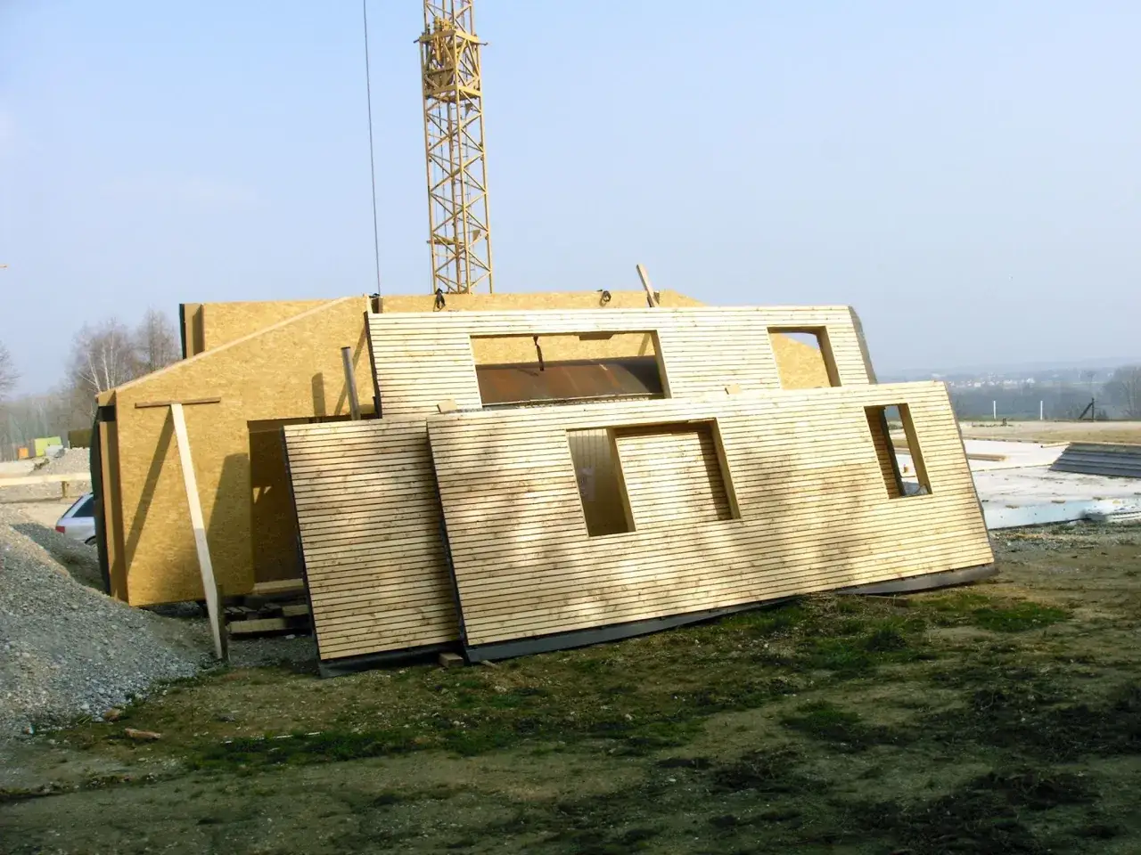 Panneaux préfabriqués pour une maison ossature bois, un avantage pour une construction rapide et écologique. Grue visible.