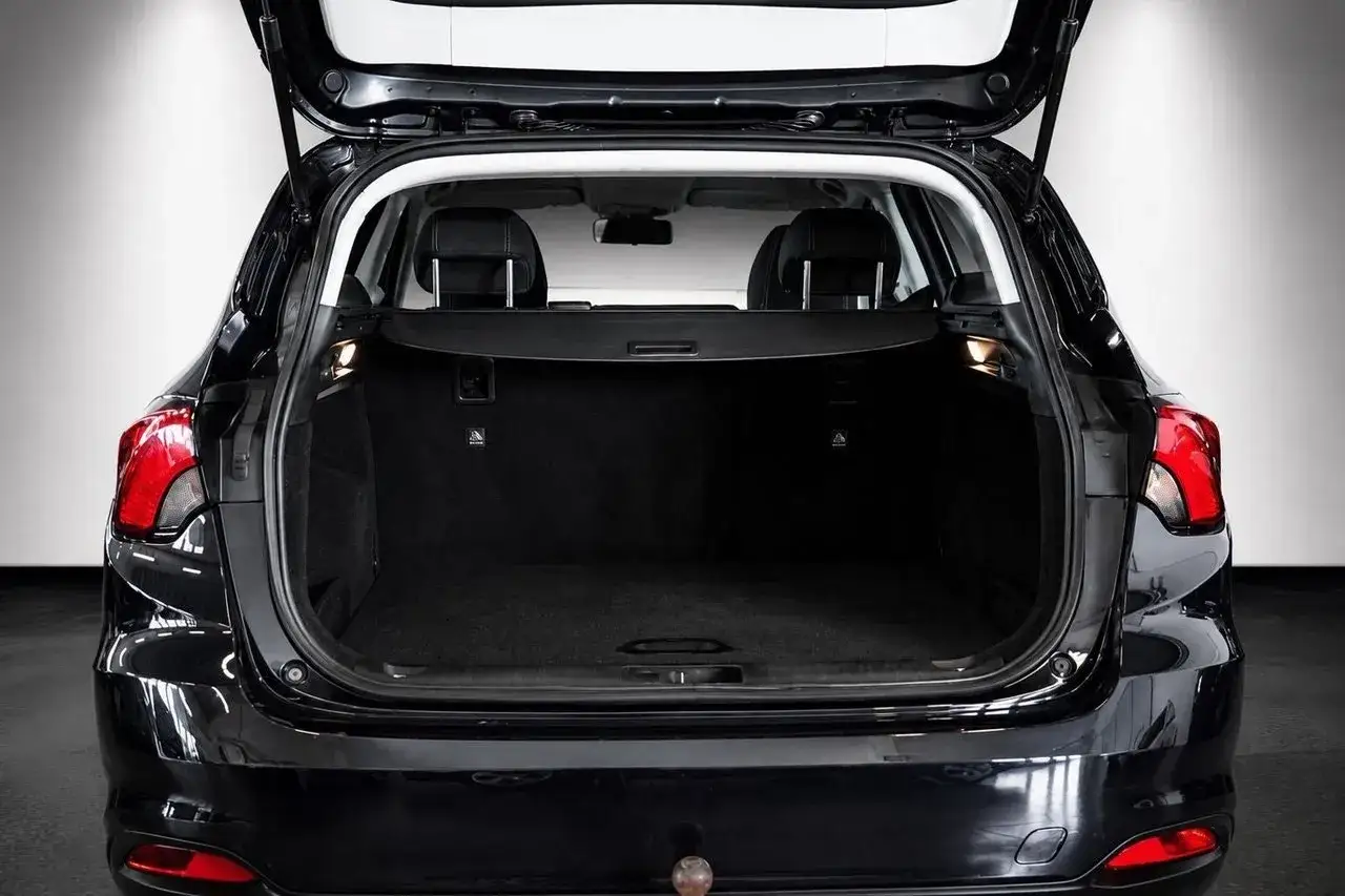 Bakluckan p&aring; en svart Fiat Tipo kombi &auml;r &ouml;ppen och visar ett rymligt, tomt lastutrymme.