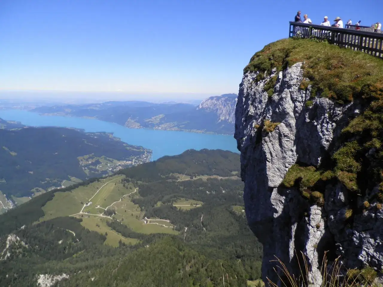 Blick von der Himmelspforte am Schafberg auf den türkisfarbenen See und die umliegenden Berge.
