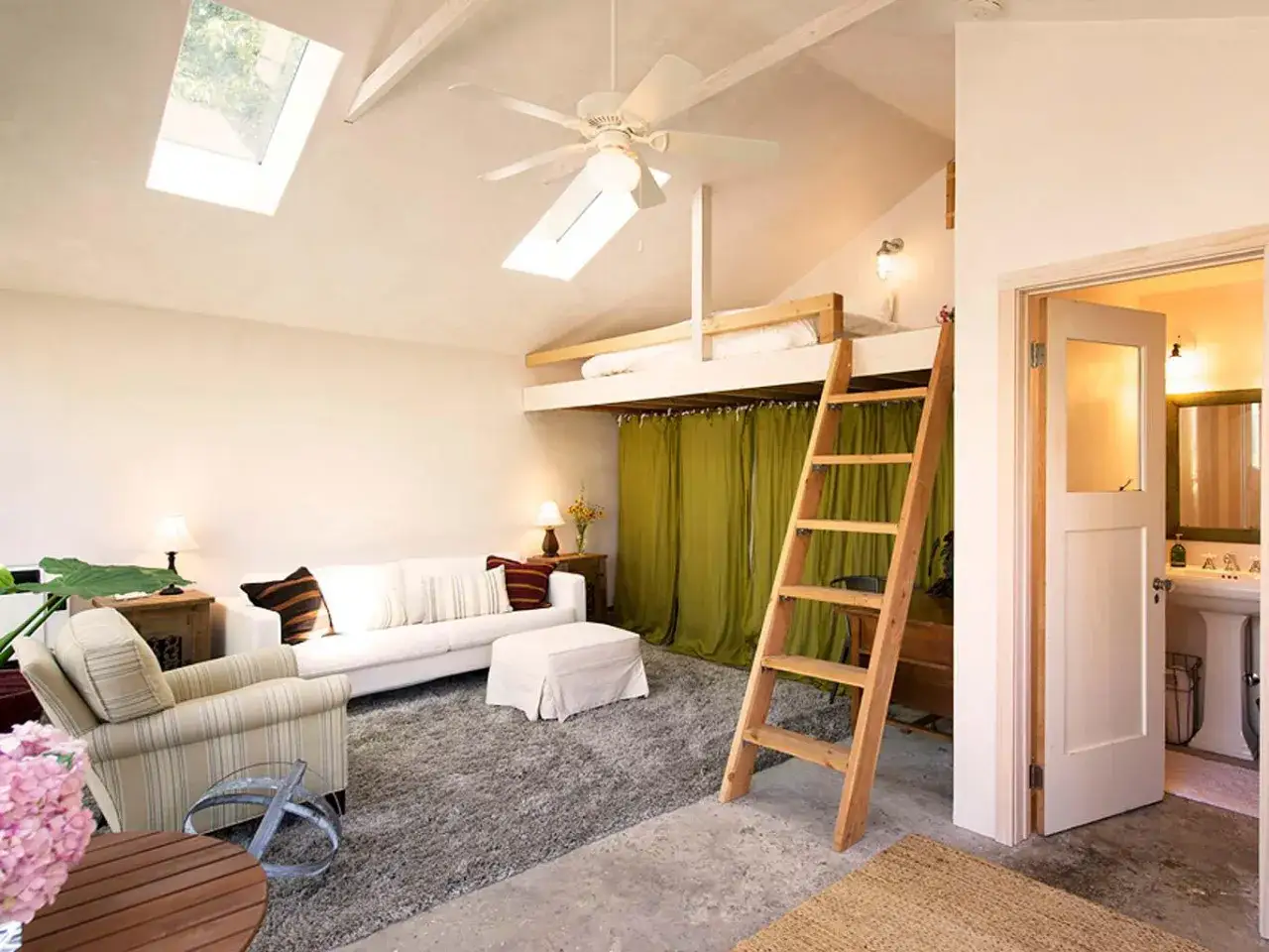 Trasformare un garage in abitazione: un loft con letto soppalcato, divano, poltrona e bagno. Costo variabile.