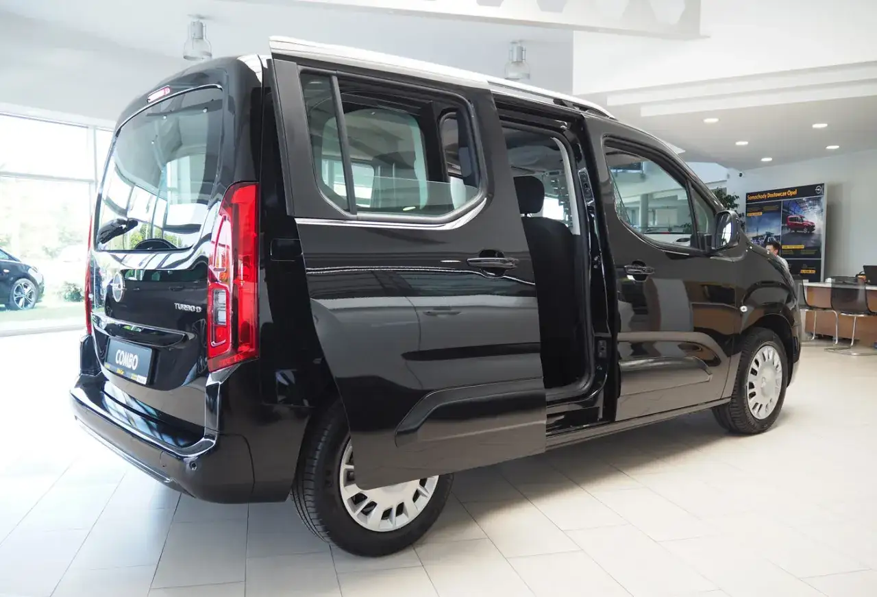 Czarny Opel Combo, jeden z wielu praktycznych minivany, z otwartymi drzwiami, gotowy na rodzinne przygody.