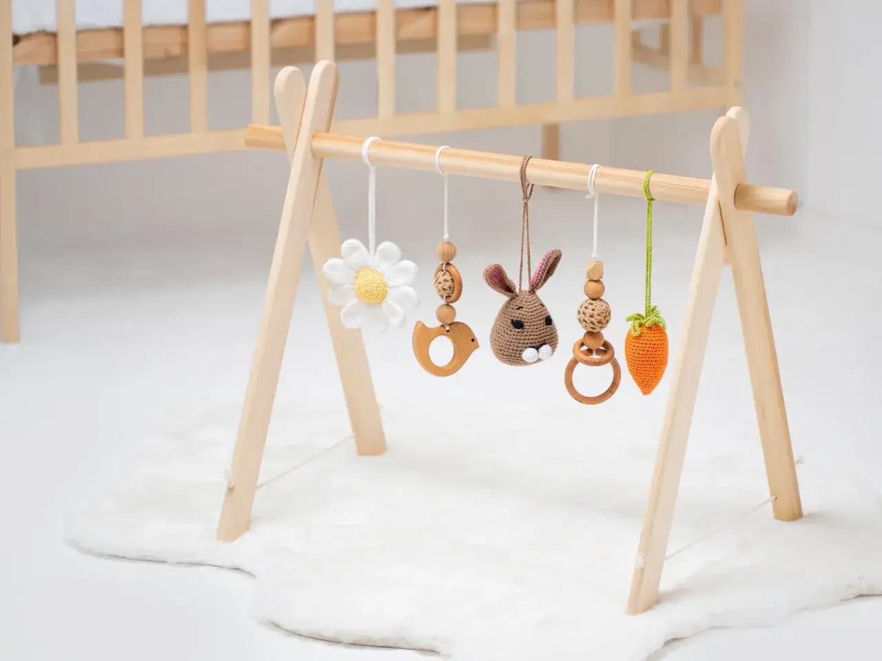 En babygym med en virkad kanin, en blomma, en f&aring;gel och en morot. Perfekt f&ouml;r sm&aring; h&auml;nder att utforska.