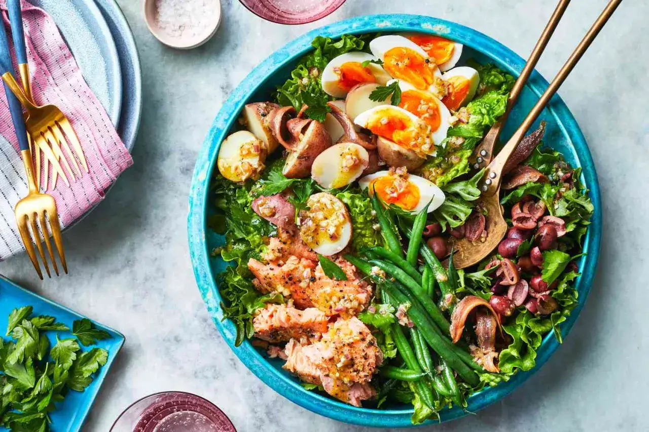 En stor, matig sallad med lax, &auml;gg, potatis, gr&ouml;na b&ouml;nor och oliver.