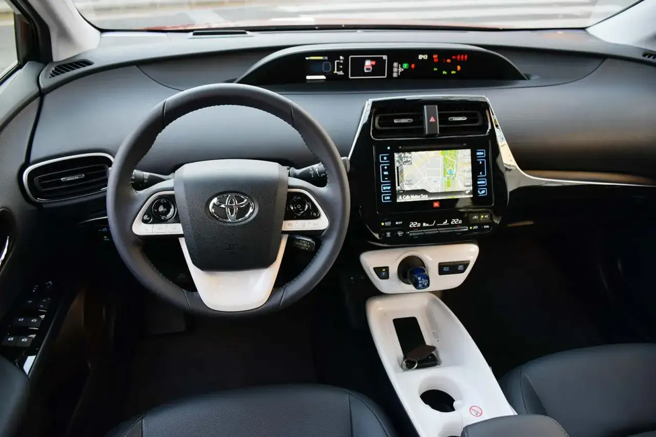 Wnętrze Toyoty Prius 4: kierownica, ekran nawigacji i konsola środkowa.
