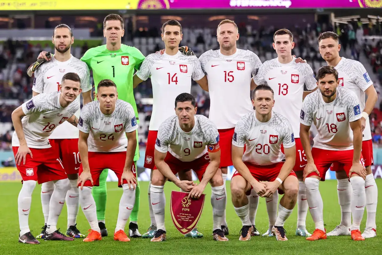 Drużyna Polski na boisku. Robert Lewandowski z tarczą PZPN. Średnia wieku reprezentacji Polski to doświadczenie i młodość.