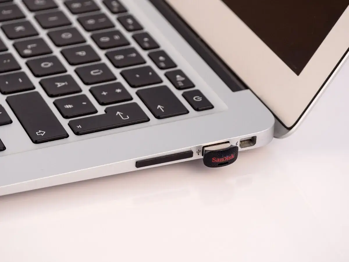 Ein SanDisk USB-Stick ist in einen MacBook-Anschluss gesteckt.