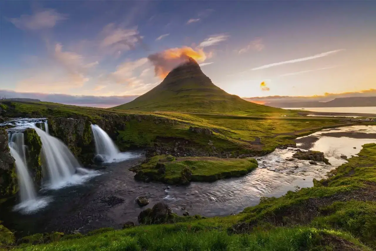 Cascada y monta&ntilde;a ic&oacute;nicas en los fiordos de Islandia al atardecer.