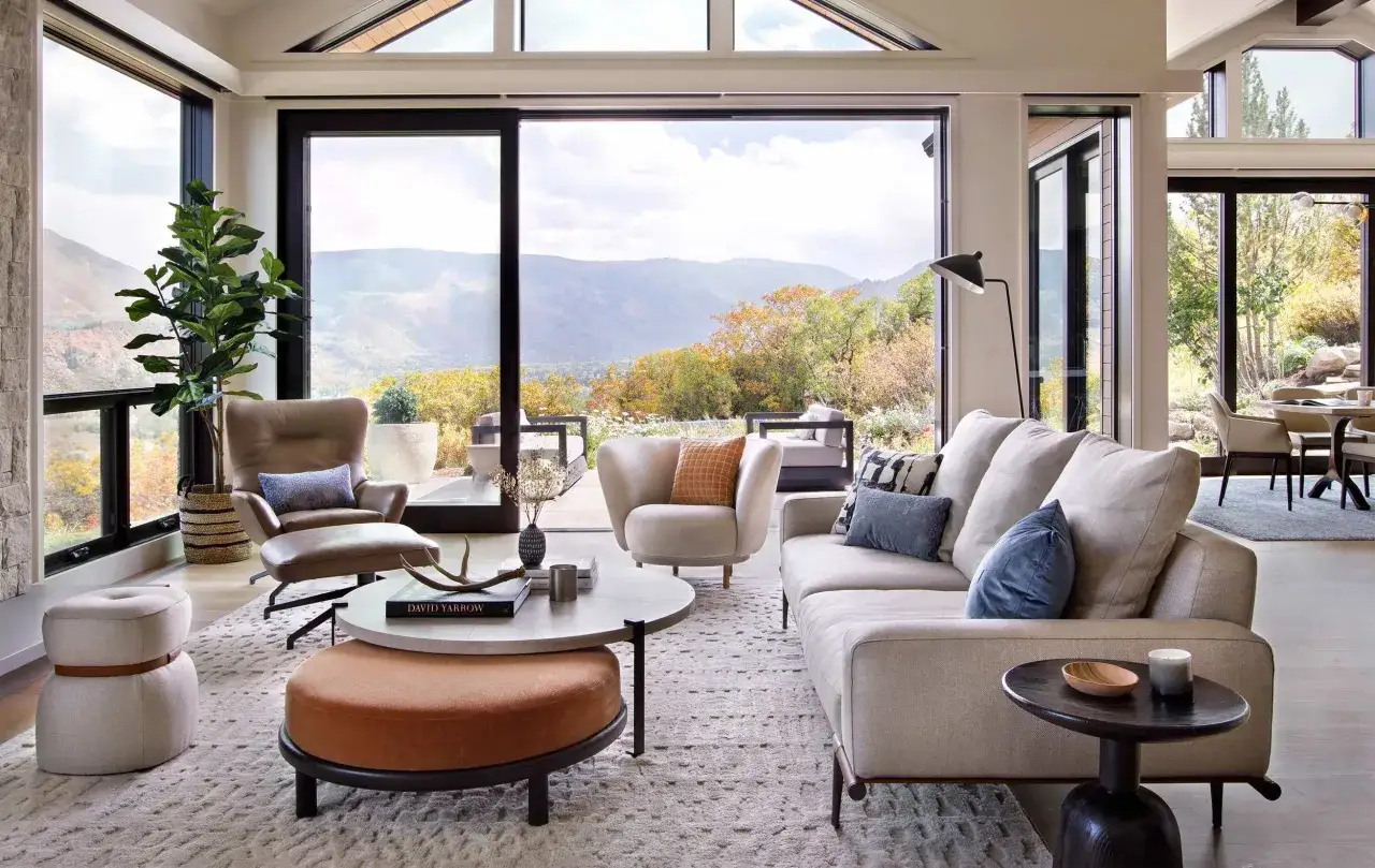 Gem&uuml;tliche luxus chalet inneneinrichtung mit bequemen Sofas, Sesseln und einem atemberaubenden Bergblick durch bodentiefe Fenster.