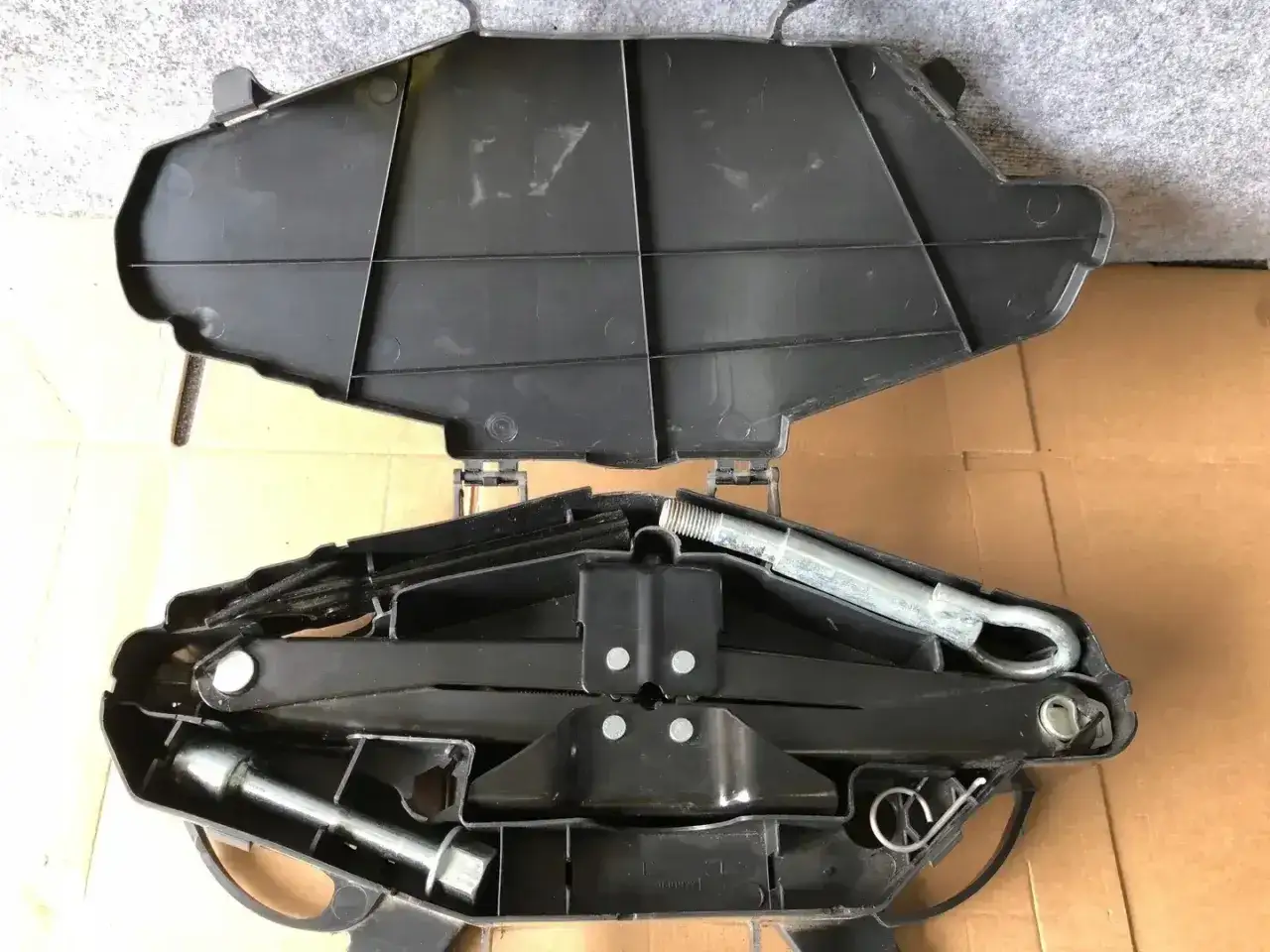 Zestaw narzędzi do wymiany koła w Renault Trafic. Lewarek i klucz do kół schowane w czarnym futerale.