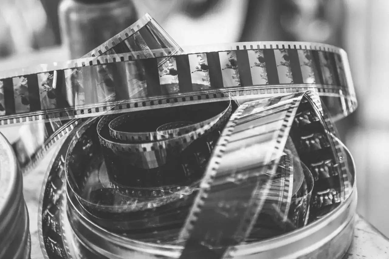 Zwoje taśmy filmowej, każdy kadr to negatyw wspomnień.