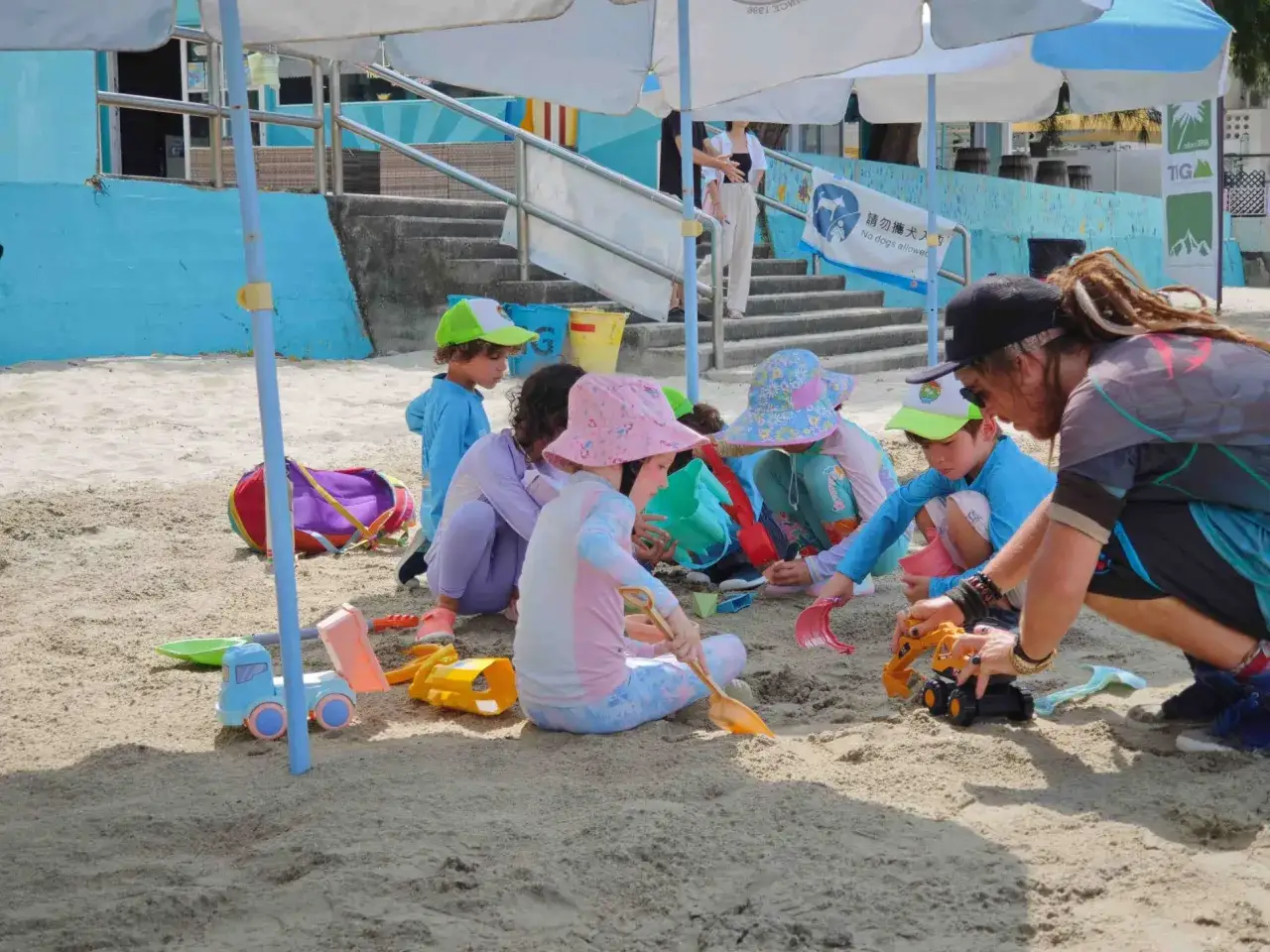 Ni&ntilde;os disfrutan de juegos en la playa sin material, construyendo con arena y juguetes.