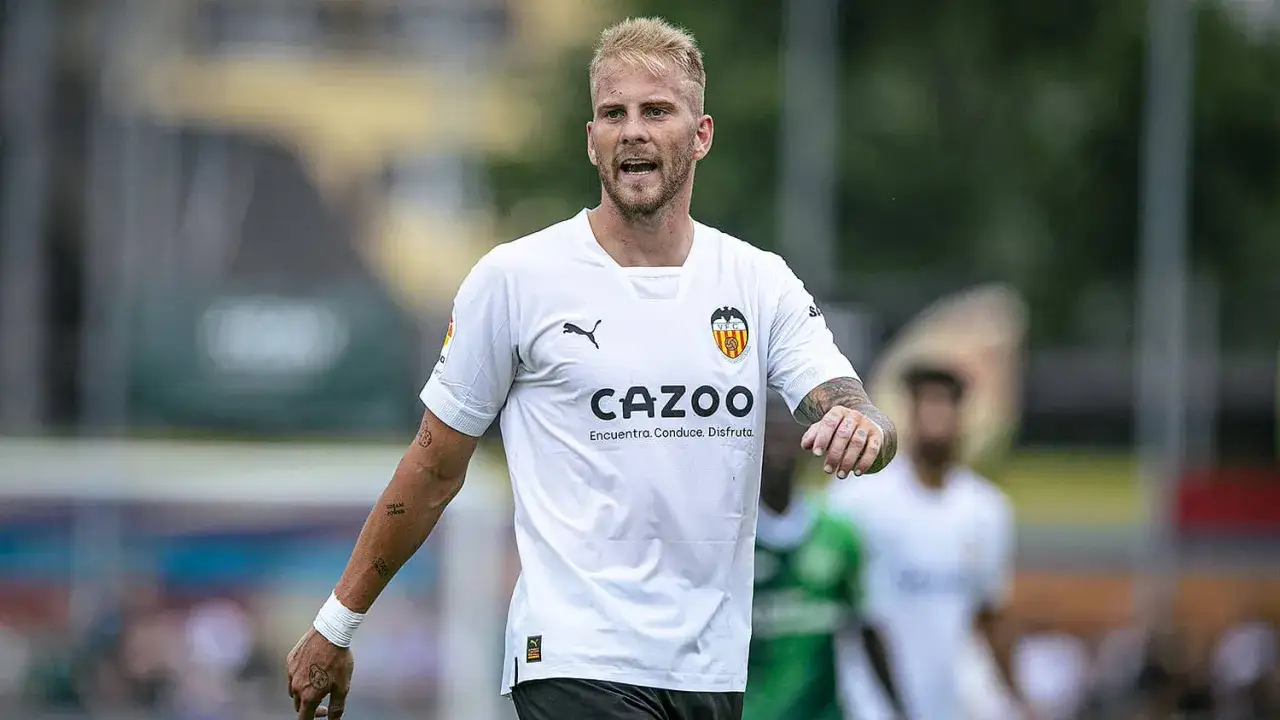 Uros Racic, jugador del Valencia CF, con el uniforme blanco y el logo de Cazoo.