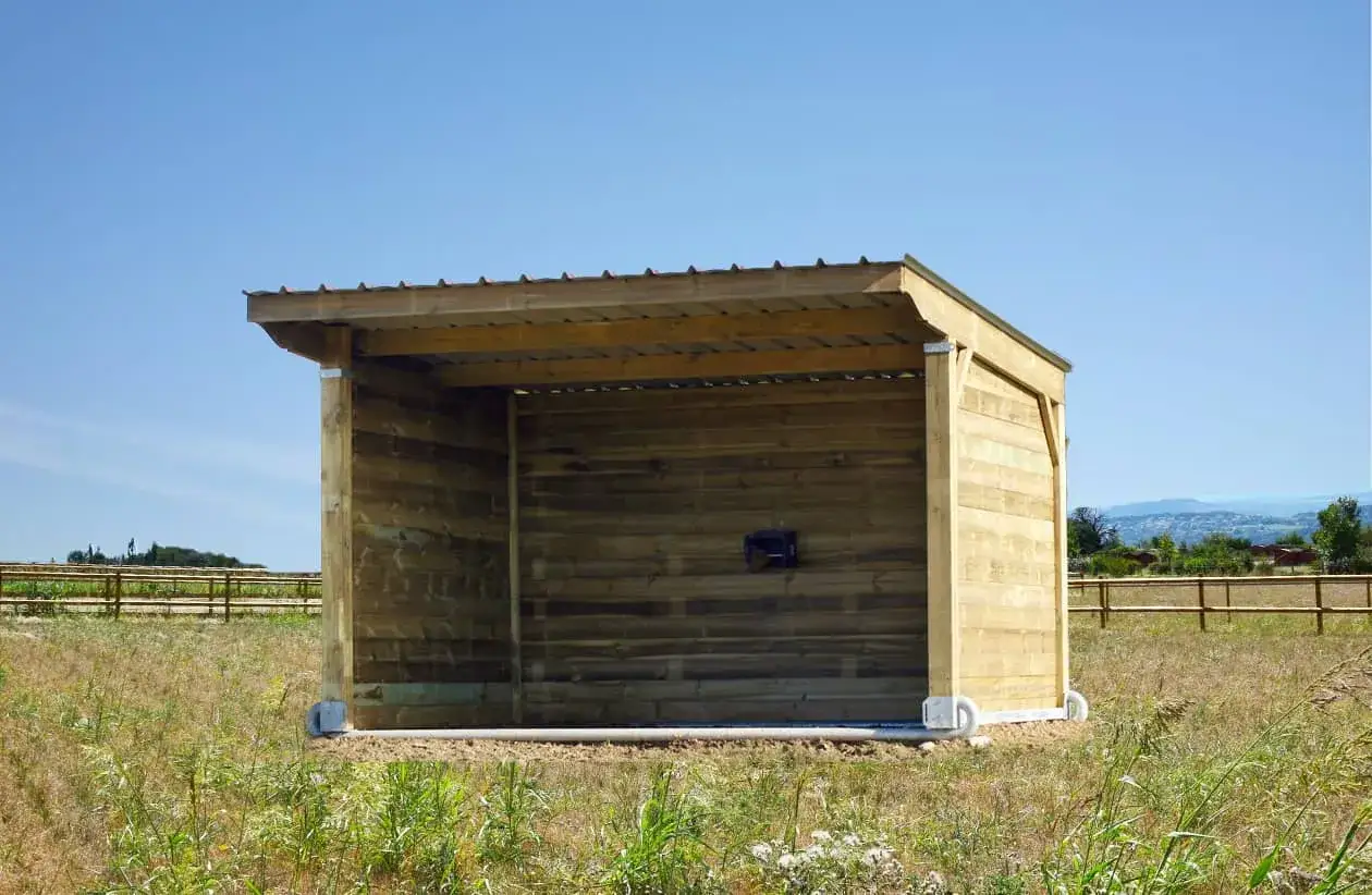 Abri en bois pour cheval sur terrain privé, respectant la réglementation.