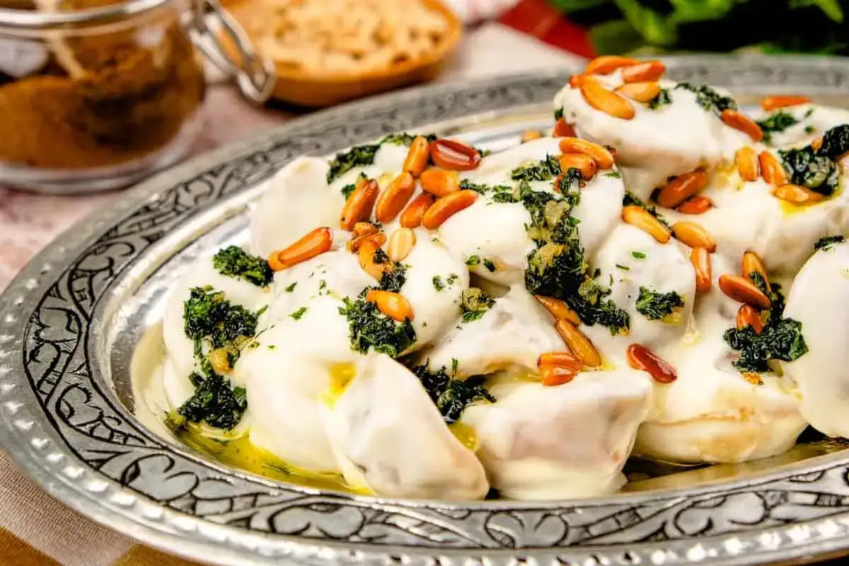 Shish barak, sm&aring; dumplings i en kr&auml;mig yoghurts&aring;s, toppad med &ouml;rter och rostade pinjen&ouml;tter p&aring; en vackert m&ouml;nstrad silverbricka.